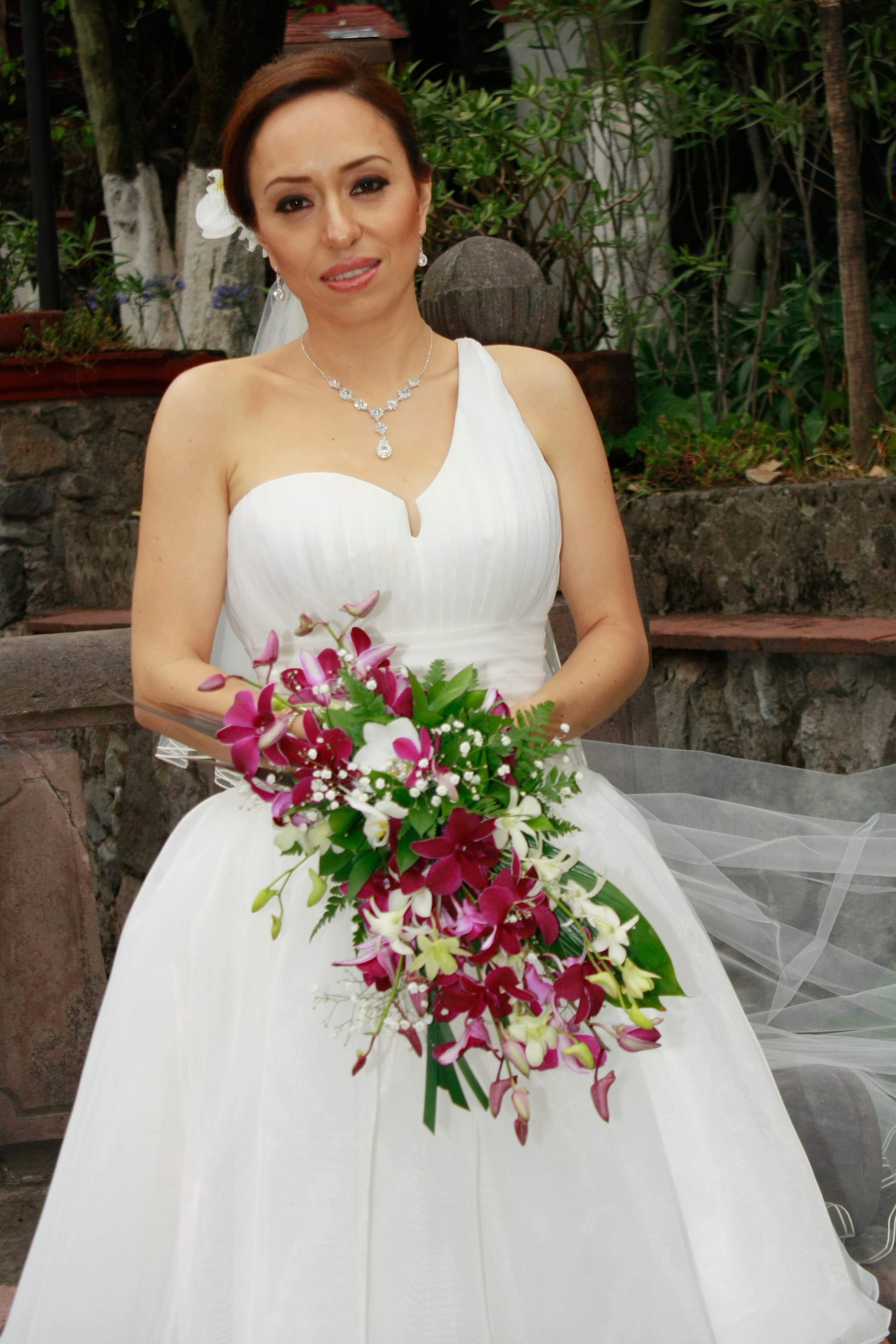 Clienta de Mía Najar con vestido de novia y ramo de orquídeas